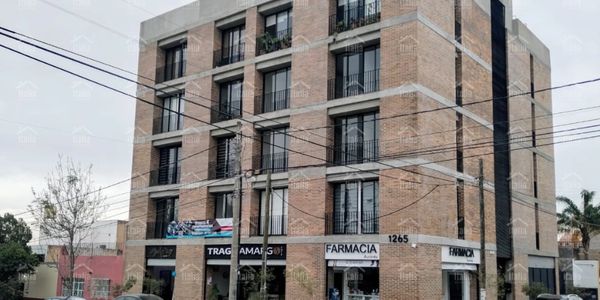 Modern brick building with shops on the ground floor and residential units above.
