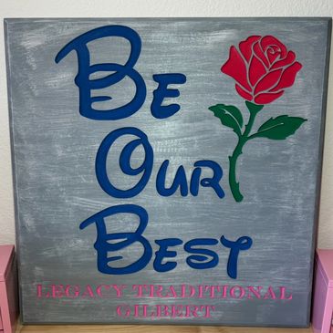 Decorative sign with a red rose and motivational message "Be Our Best."