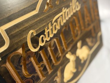 Wooden sign with the words "Cottontails" and "Chicken Salad" carved.