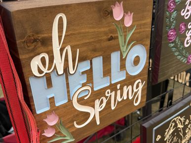 Decorative wooden sign saying 'oh HELLO Spring' with pink tulips.