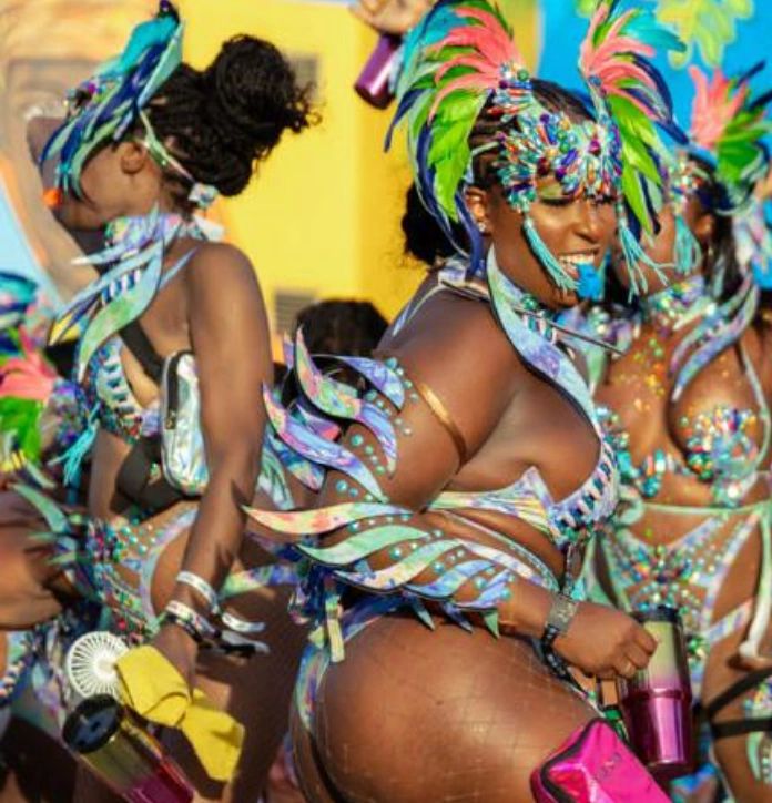 Women in colorful carnival costumes dancing joyfully.