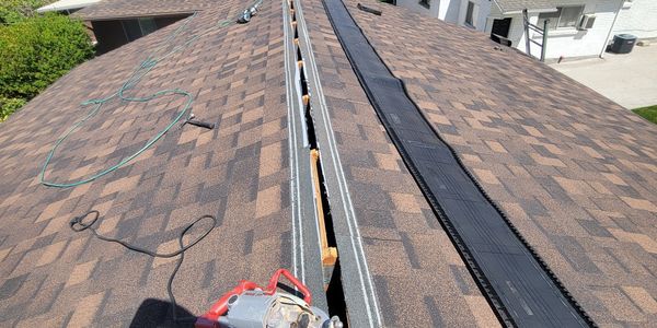 Roof ridge open with tools and materials for repair.