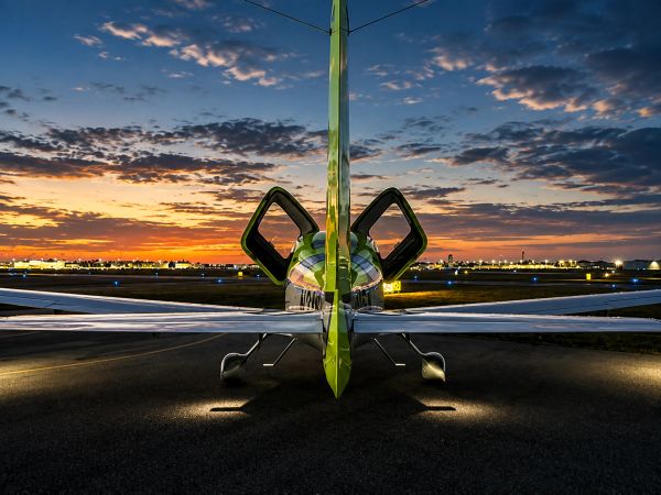 Small airplane at sunset with open doors.
