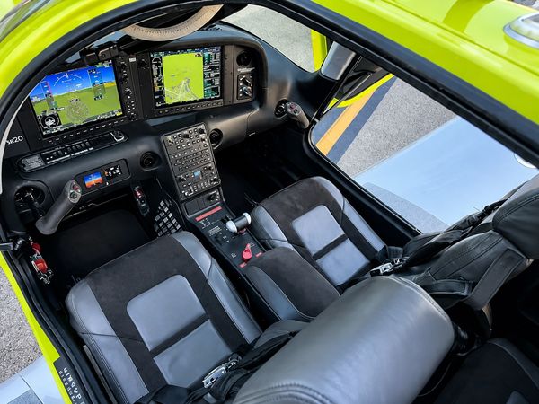 Cockpit of a modern aircraft with two seats and advanced controls.