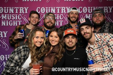 Group of friends enjoying Country Music Night with drinks and smiles.