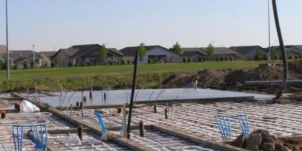 Construction site with foundation work in progress in a suburban area.