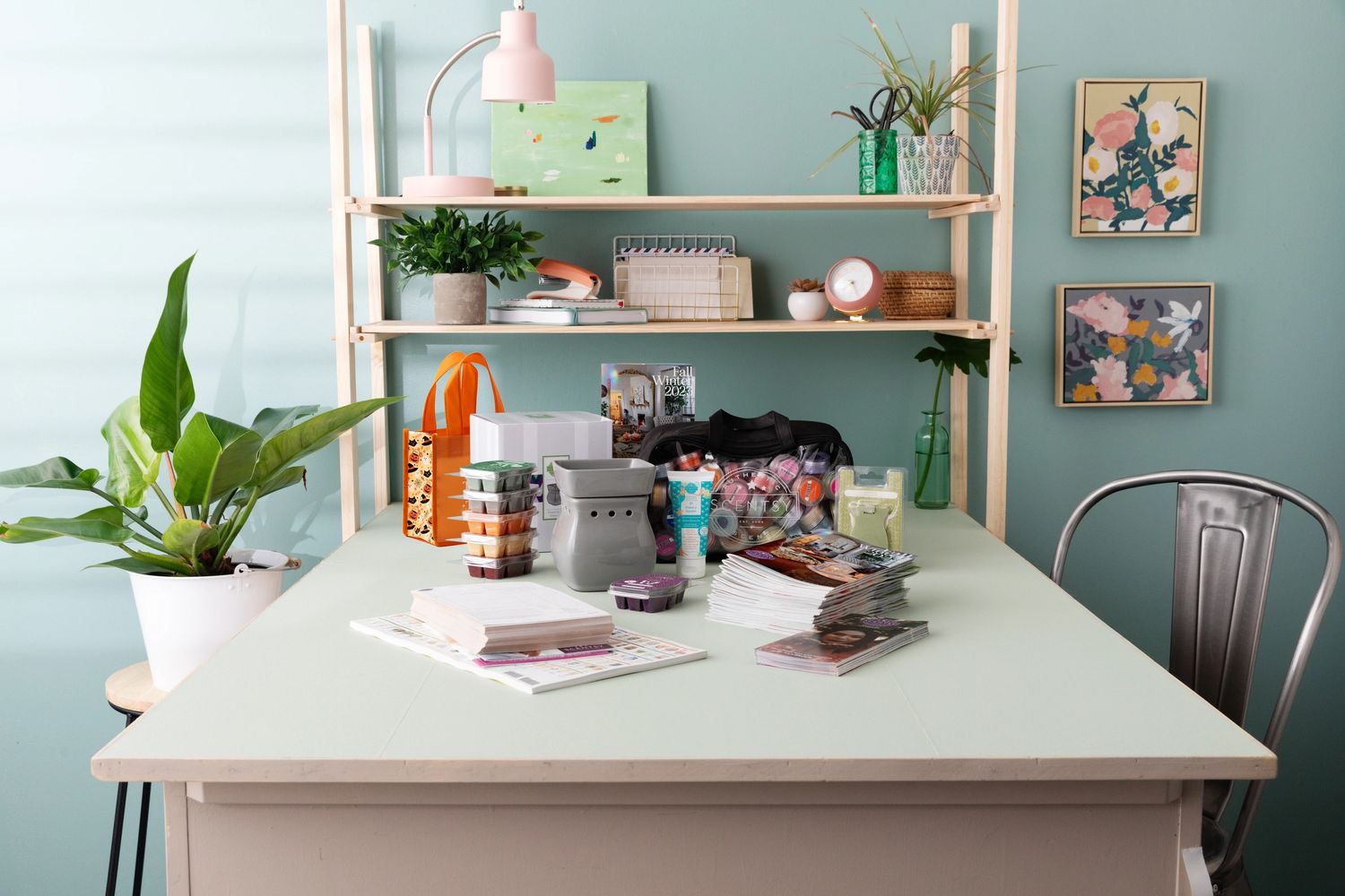 An inviting workspace filled with Scentsy catalogs, Scentsy warmers, and Scentsy Wax Bars. 