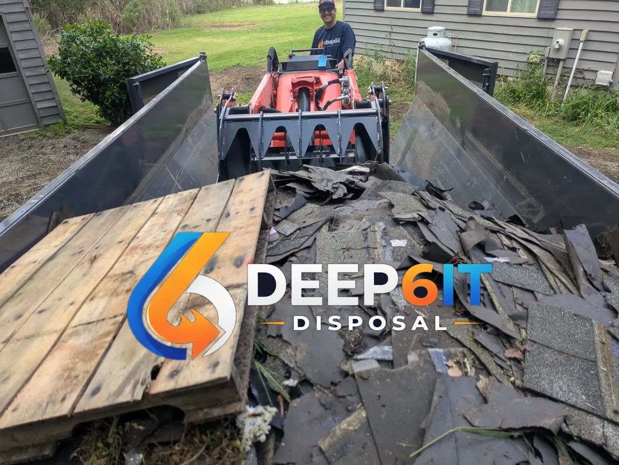 Loader carrying debris and wood pallets with Deep 6 IT Disposal logo.