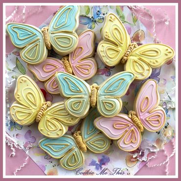 Colorful butterfly-shaped decorated cookies on a floral plate.