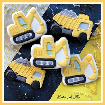 Yellow construction vehicle cookies shaped like excavators and dump trucks.