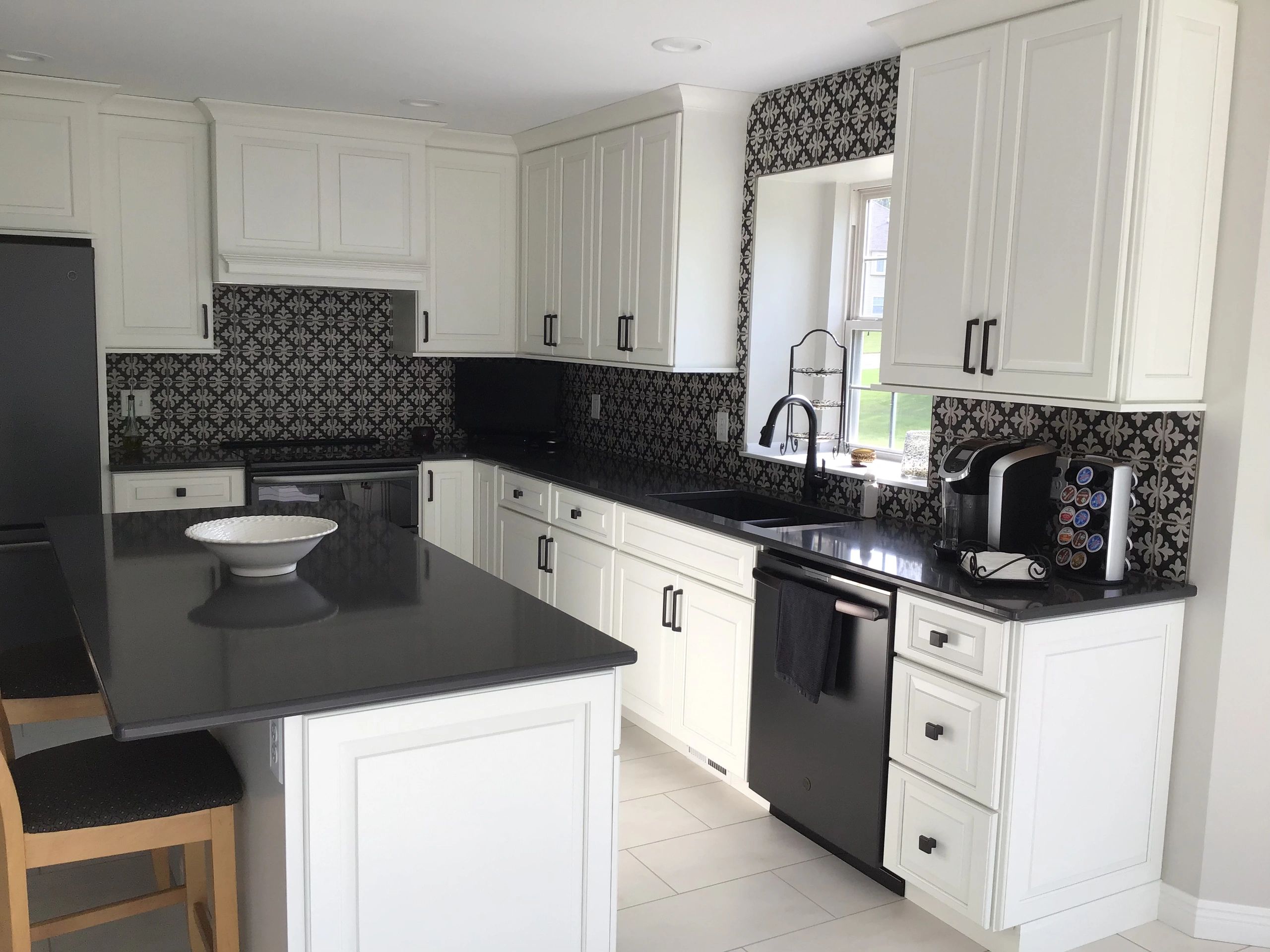 White Raised Panel Cabinetry with Black Cambria and Corresponding Tile Backsplash