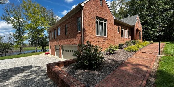 Brick house with a garden and lakeside view.