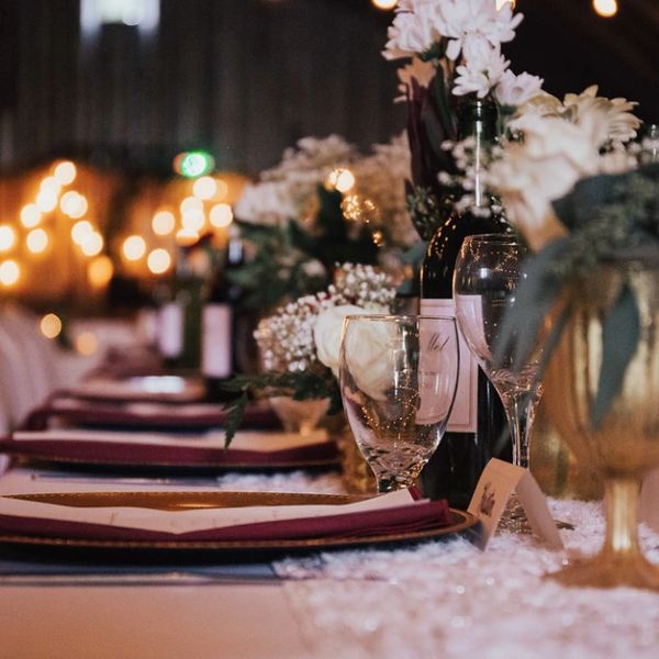 Harvest table place setting in deep rich tones and white flowers.