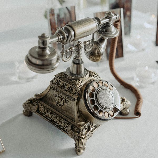 Antique slive phone with rottary dial for leaving a recorded guest message on an entrance table.