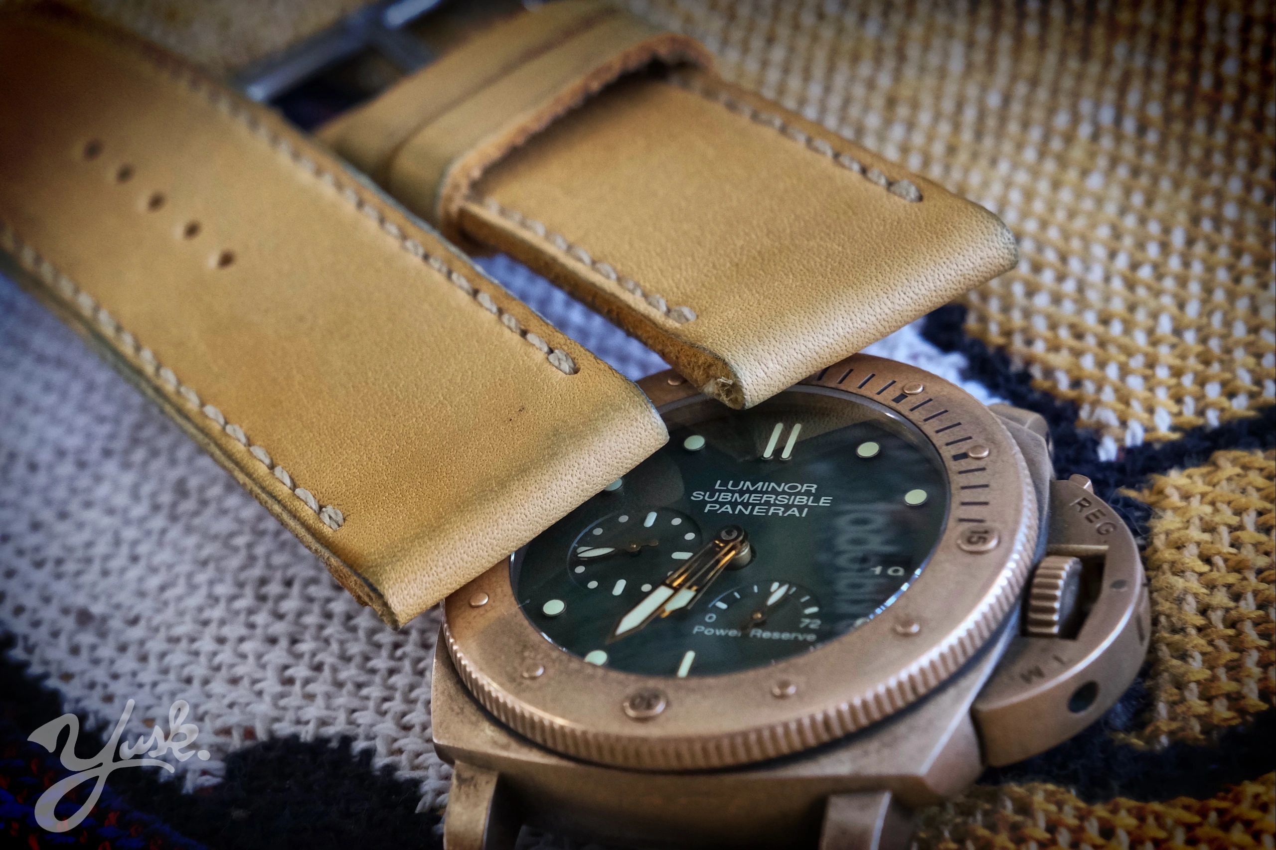 Close-up of a Luminor Submersible Panerai watch with a tan leather strap.