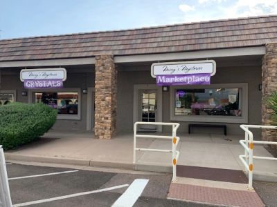 Storefronts with ‘Crystals’ and ‘Marketplace’ signs in a shopping plaza.