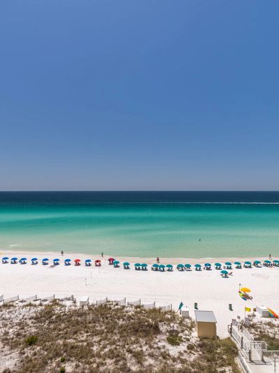 A beautiful Destin, FL day with white sand beach and emerald green water.