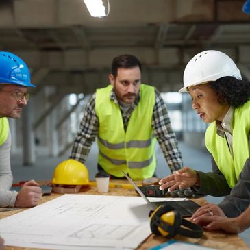 Construction team reviewing plans and discussing project details on site.