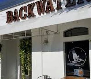 Outdoor seating area at Backwater cafe with a chair and table.