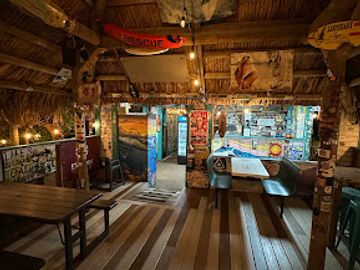 Cozy rustic bar with wooden floors and vintage surf decor.