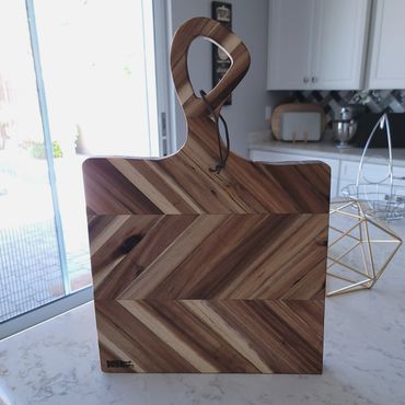 Elegant wooden cutting board with a geometric pattern on a kitchen counter.