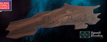 Wooden charcuterie board with custom engraving, set against a blue textured background.