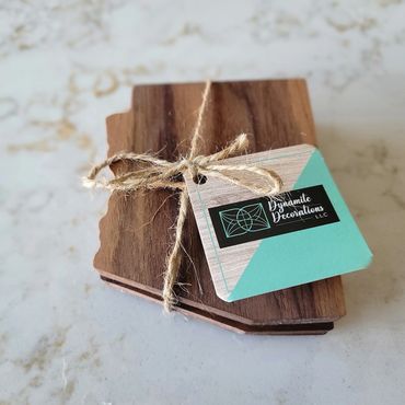 Wooden coasters shaped like a state, tied with twine and a decorative tag.