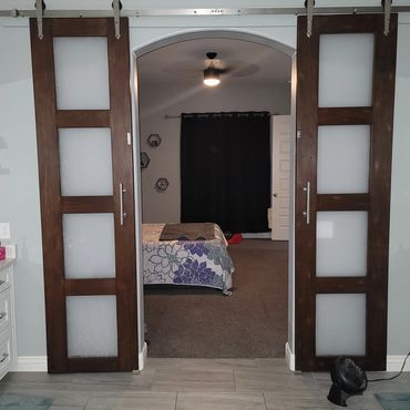 Modern sliding doors opening to a cozy bedroom with floral bedding.