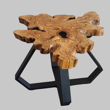 Unique wooden table with natural edge and geometric metal legs.