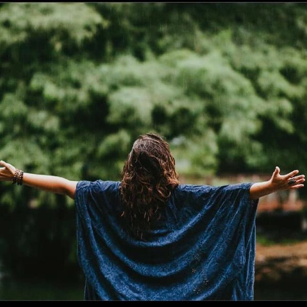 Person enjoying nature with arms wide open.