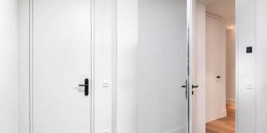 Minimalist white hallway with doors.
