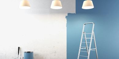 Partially painted blue wall with a ladder.