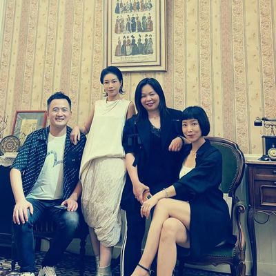 Group of four people posing indoors in vintage-style room.