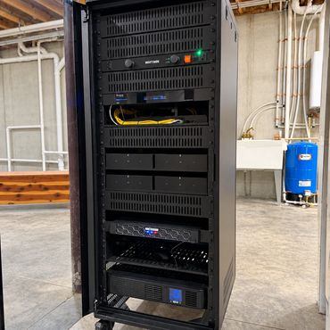 Professionally installed AV, networking, and security equipment rack with organized wiring, power pr