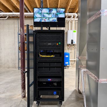 Professionally installed AV, networking, and security equipment rack with organized wiring, power pr