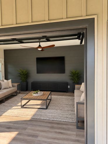 Custom outdoor entertainment space featuring a professionally mounted TV, in-ceiling speakers, and a