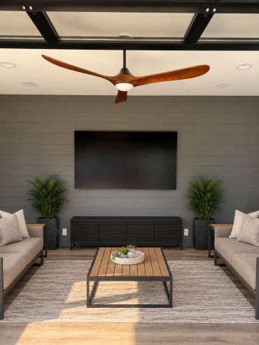 Custom outdoor entertainment space featuring a professionally mounted TV, in-ceiling speakers, and a