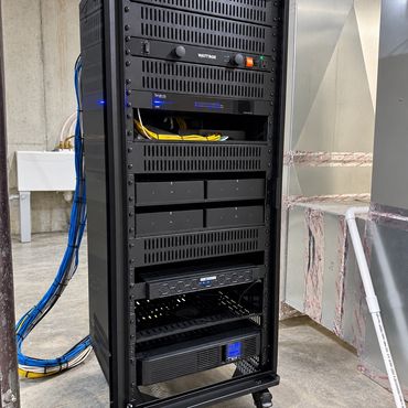 Professionally installed AV, networking, and security equipment rack with organized wiring, power pr