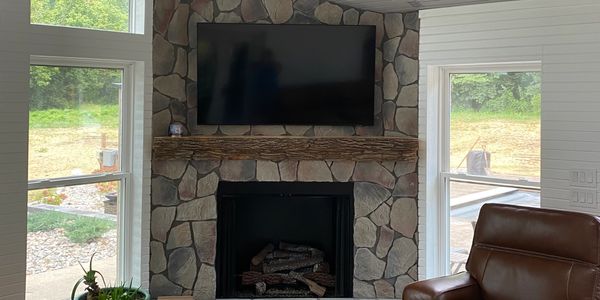 Wall mounted TV installation on stone fireplace with clean cable concealment in Cincinnati Ohio