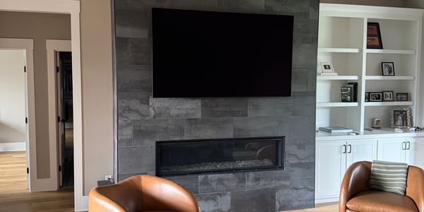 TV mounting installation above fireplace in a modern living room in Cincinnati Ohio