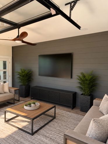 Custom outdoor entertainment space featuring a professionally mounted TV, in-ceiling speakers, and a
