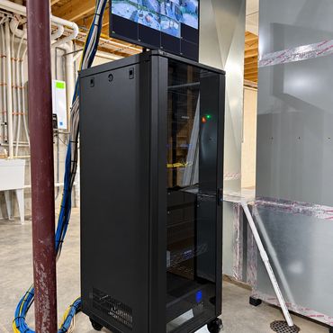 Professionally installed AV, networking, and security equipment rack with organized wiring, power pr