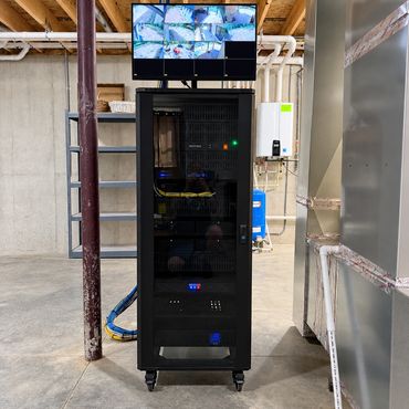 Professionally installed AV, networking, and security equipment rack with organized wiring, power pr