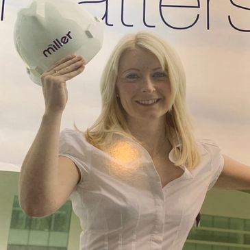 Woman holding a hard hat on the cover of Miller magazine.