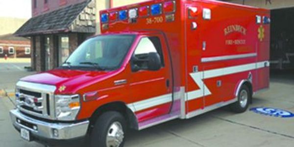 Bright red fire rescue ambulance parked outside a building.