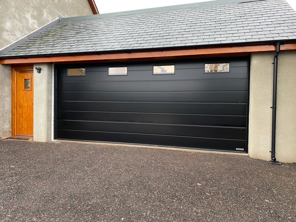 Photo of the finished product, a black fully insulated Hormann sectional garage door