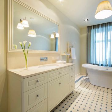 This bathroom has a standing bath,cream wall's with light blue accents.vanity with built in sink