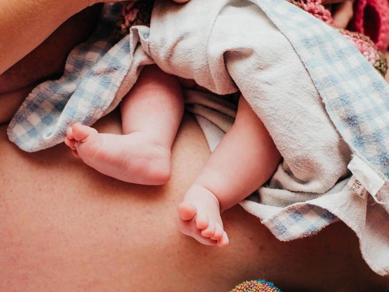 Close-up of baby feet wrapped in a blanket.