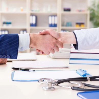 Handshake between doctor and patient in office.