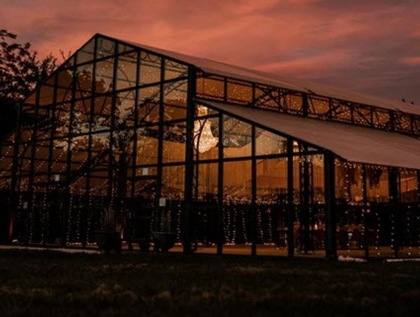Glass building illuminated with warm lights at sunset.